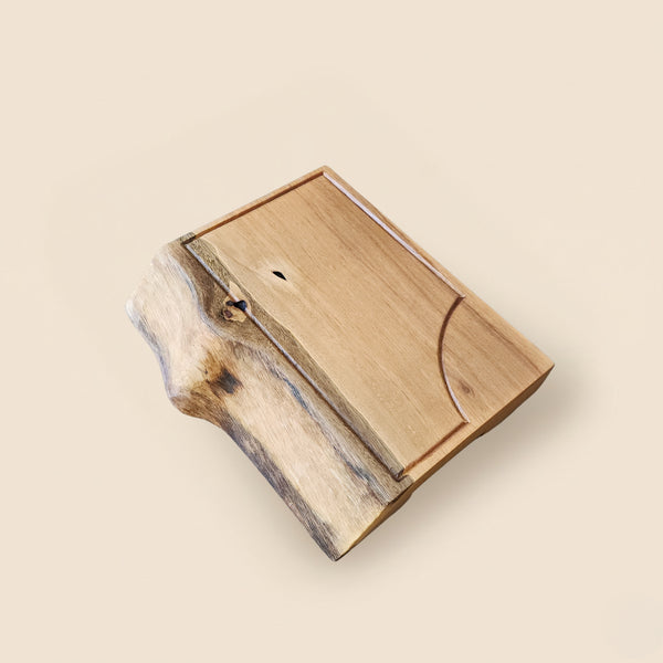 Tábua de carne em madeira maciça com bloco sólido e veios naturais contrastantes, acabamento artesanal em óleo natural