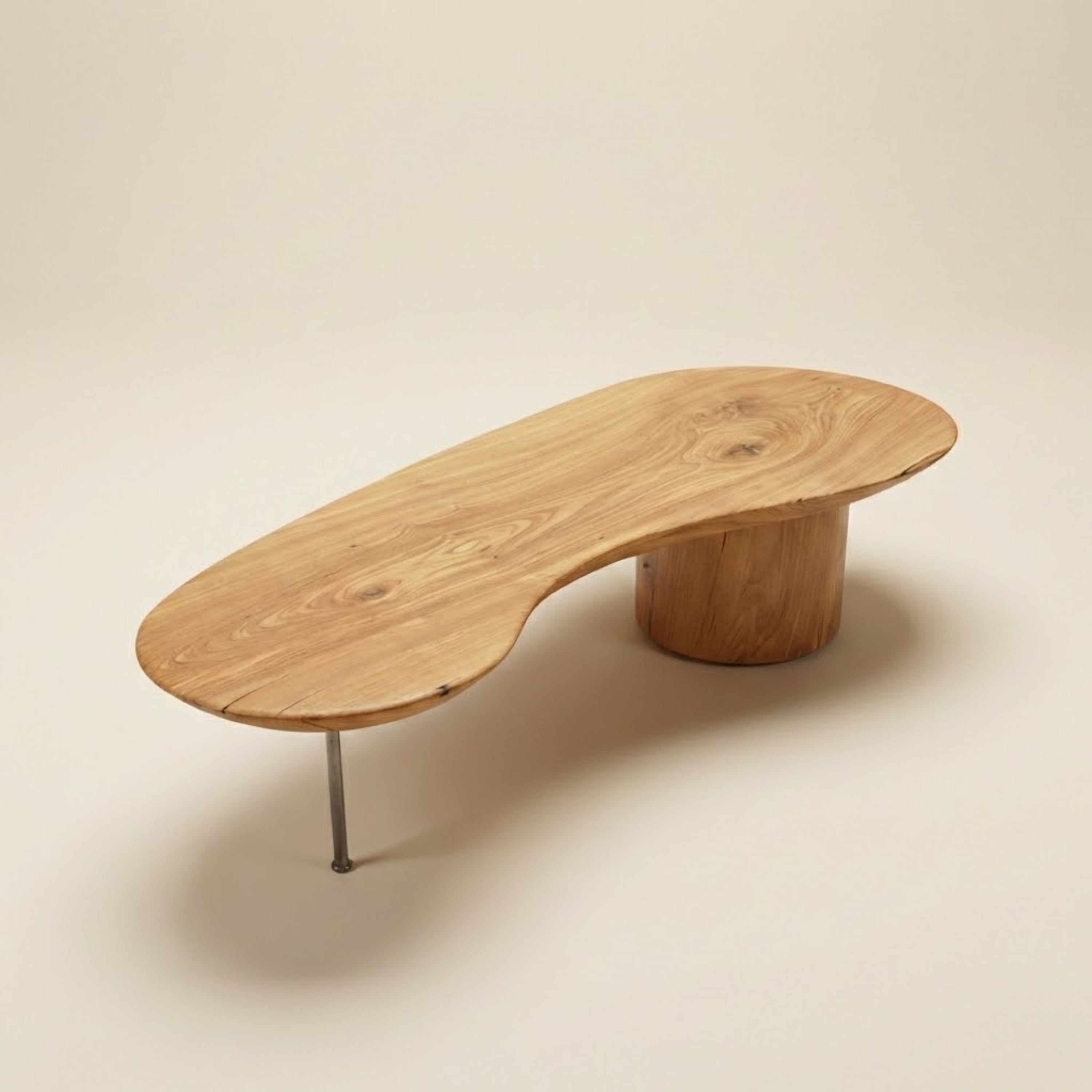 Mesa de centro Bean ArboREAL em madeira maciça, com tampo orgânico de linhas fluidas, espessura generosa e veios naturais aparentes, apoiada sobre base cilíndrica de madeira e pé metálico discreto, em fundo neutro de estúdio