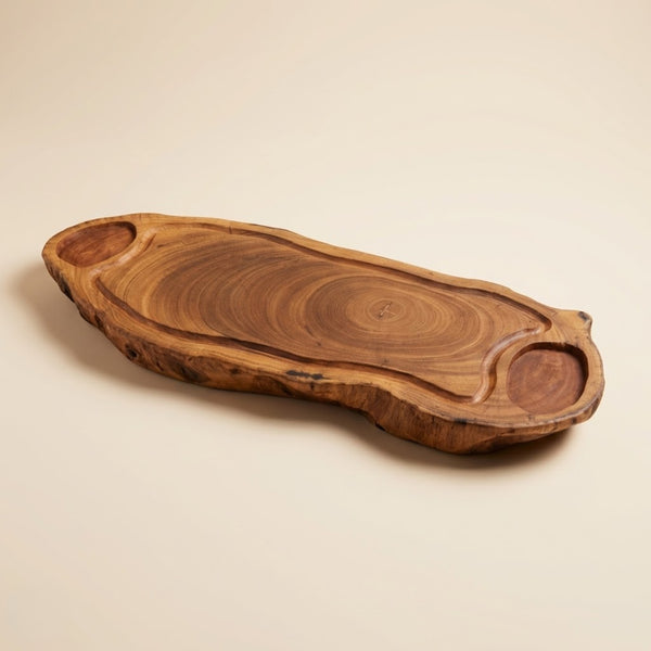 Tábua de madeira maciça ArboREAL com formato orgânico alongado, veios naturais aparentes e cavidades laterais esculpidas à mão, acabamento em óleo natural.

